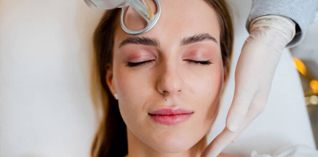 Dermatologist performing CO2 laser treatment on woman