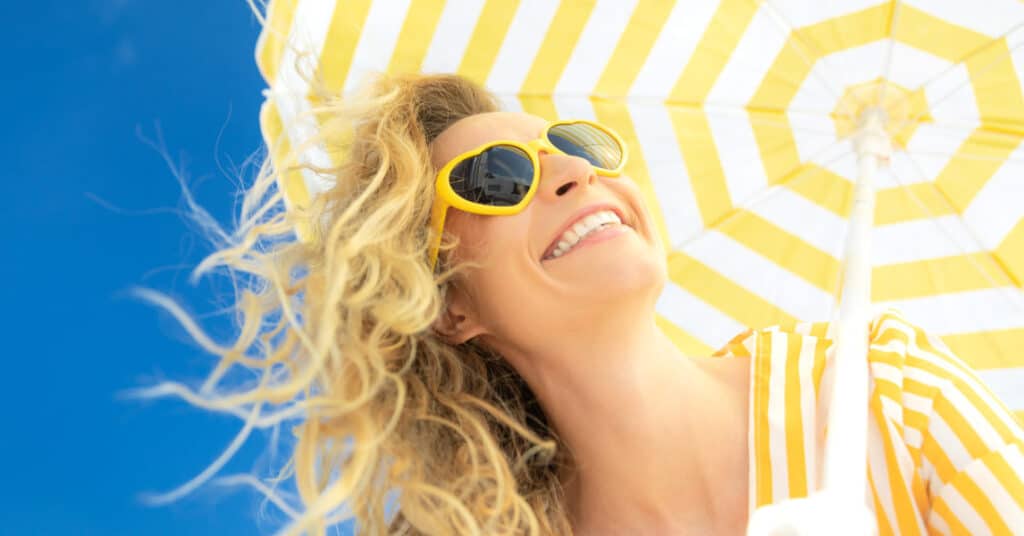Woman smiling outdoors and feeling confident after applying sunscreen