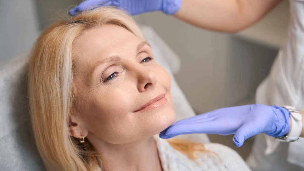 Board-certified dermatologist performing a facial skin assessment before discussing exosome treatment options