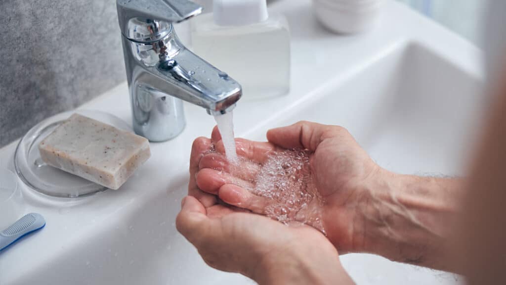 Man washing his hands after applying fluorouracil cream