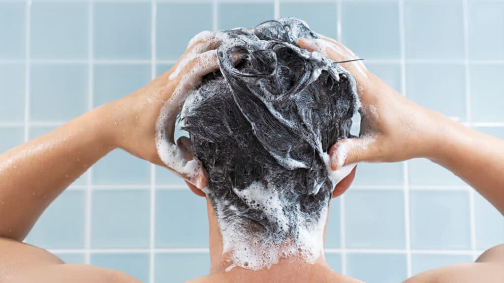 Man washing his hair with medicated shampoo to treat seborrheic dermatitis