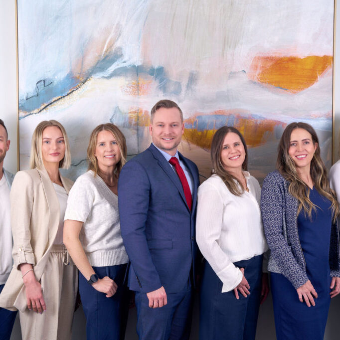 Four business professionals in front of abstract painting.