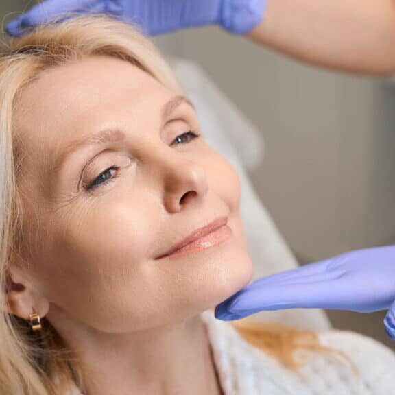 Board-certified dermatologist performing a facial skin assessment before discussing exosome treatment options